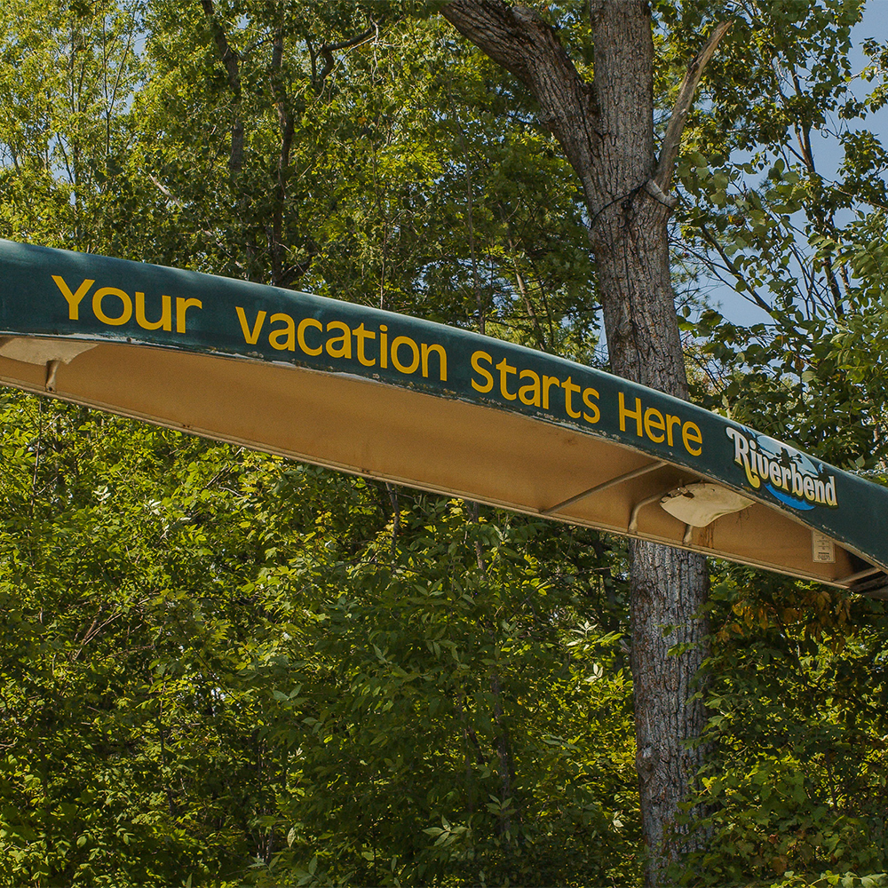 Upside down canoe serving a part of an archway has ’Your vacation starts here’ written along the side of the canoe