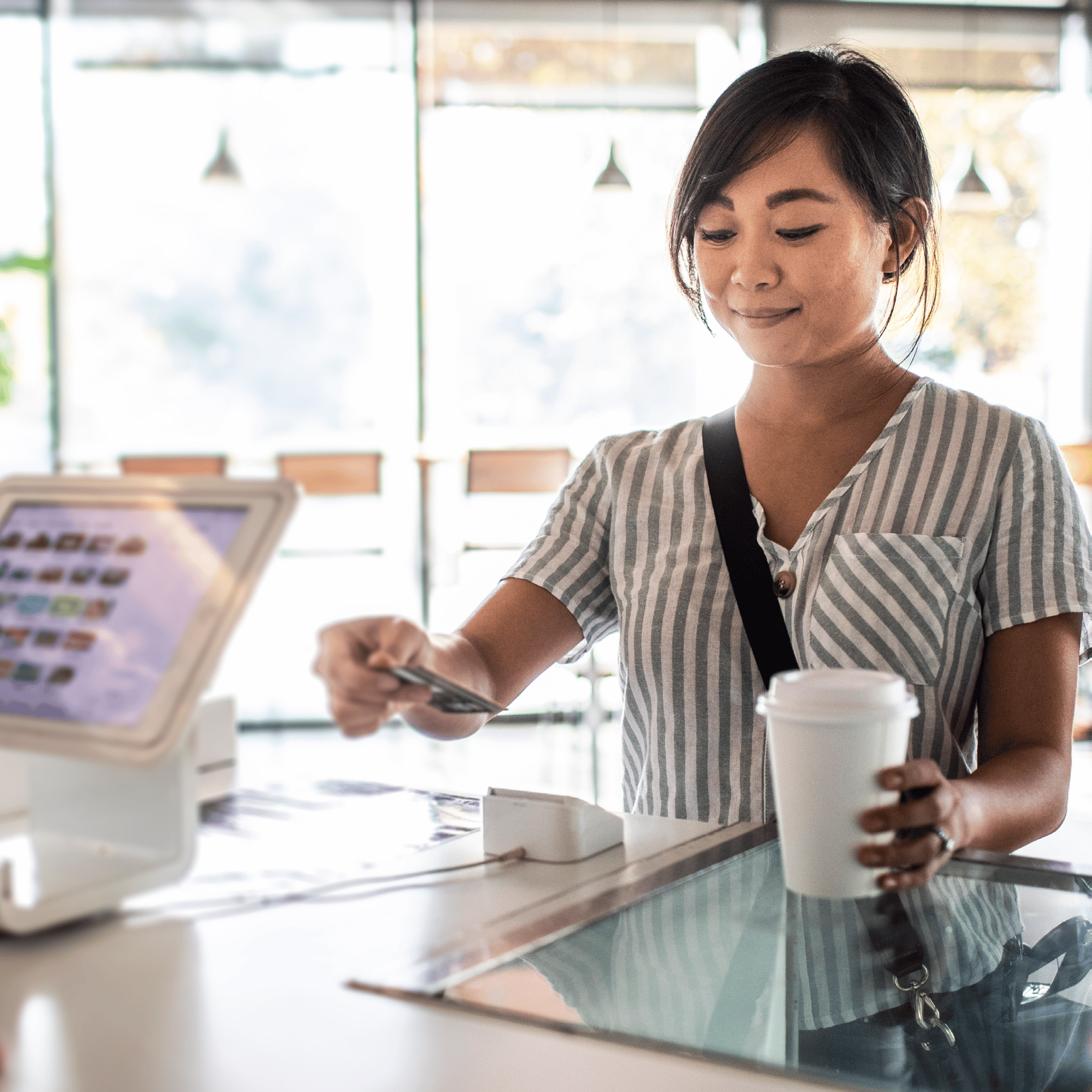 woman at the checkout counter of a retail store, handing over her credit card